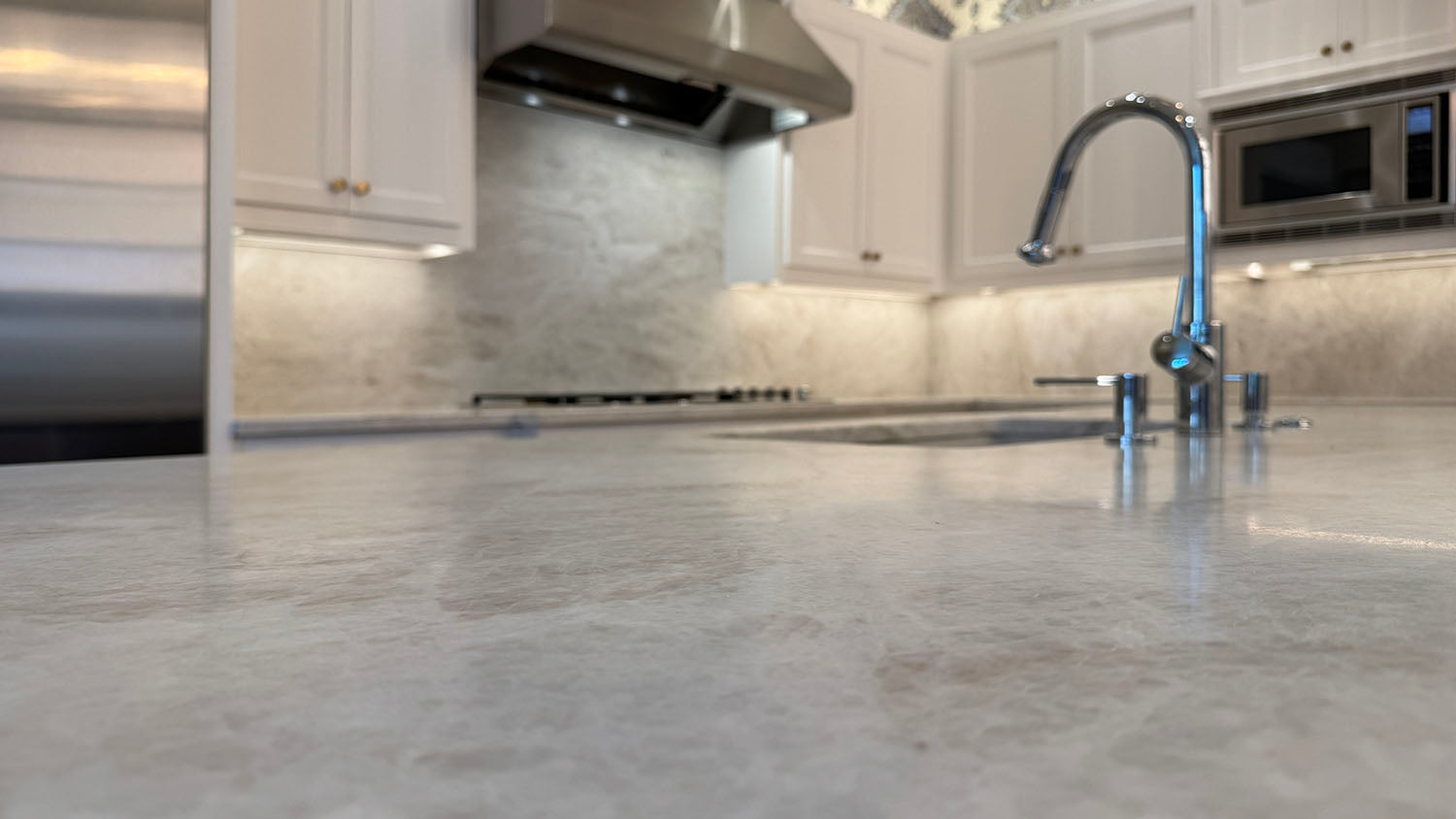 Leathered Taj Mahal countertops on the island, stainless steel applieces