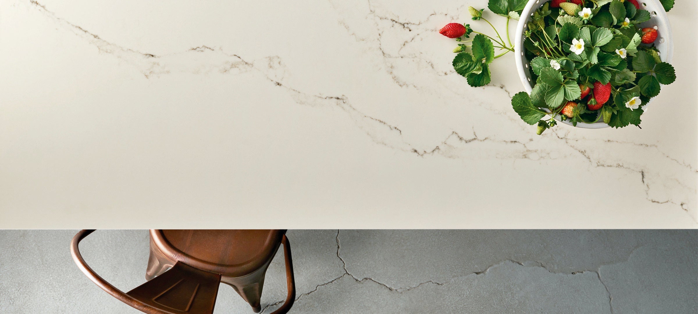 statuario nuvoletti caesarstone table with strawberries and brown chair