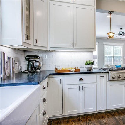 Dark soap stone with white kitchen cabinets, white large cast iron farm sink