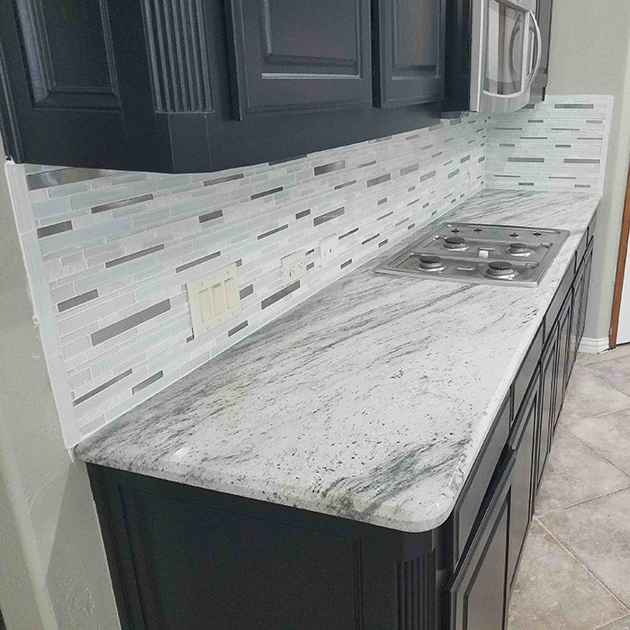 dark grey cabinets with light green grey river white granite countertops