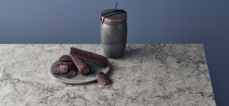 purple corn with grey plate on turbine grey counters with blue background