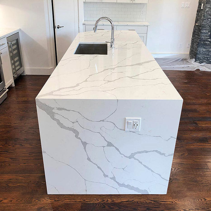 calacatta sponda quartz waterfall kitchen island with stainless steel modern sink