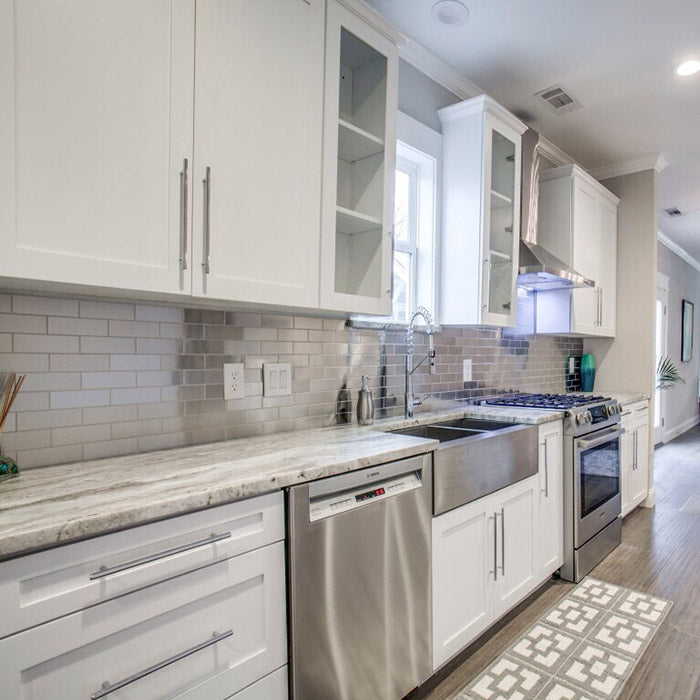 white kitchen cabinets with fantasy brown granite countertops and stainless steel farm sink, aluminum backsplash subway tile