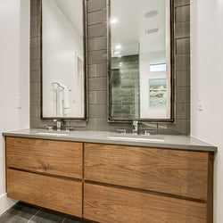 Light brown cabinets with grey quartz vanity tops and white rectangular sinks