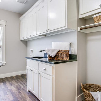Dark soap stone laundry countertops with white cabinets